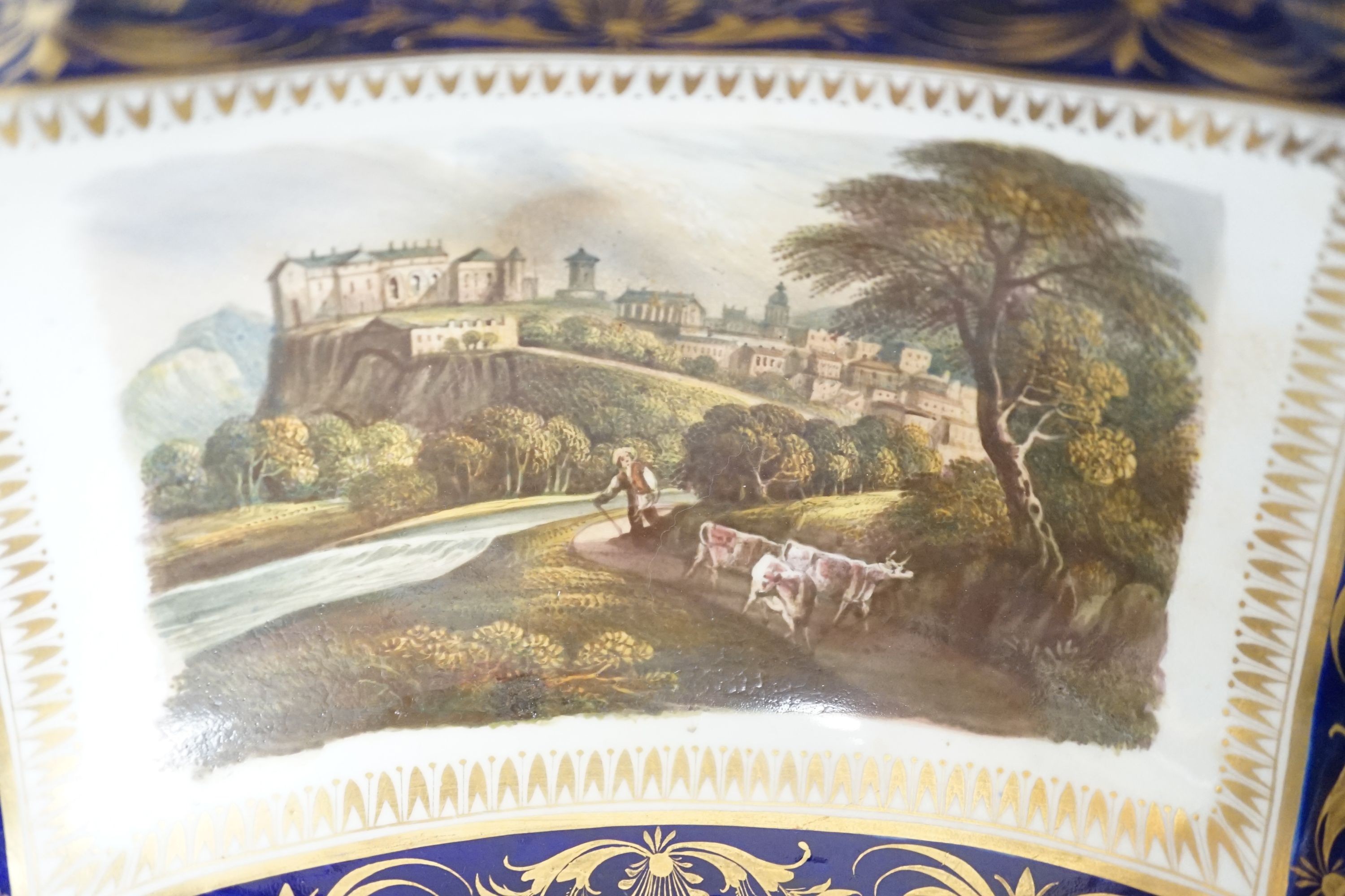 A Derby two handled pedestal dish with a named view of Sterling Castle, under a blue and gilt border probably by Daniel Lucas, c.1815, width 29cm